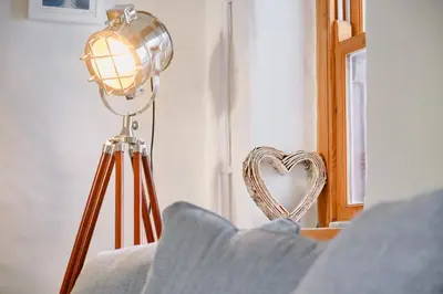 a lamp and a heart shaped mirror in a room at Finest Retreats - Scallop Cottage in Porthleven