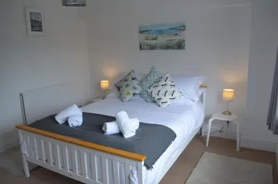 a bedroom with a white bed with towels on it at The Cottage, Treliggon Farm in Lanivet