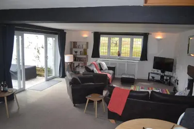 a living room with two couches and a tv at The Cottage, Treliggon Farm in Lanivet