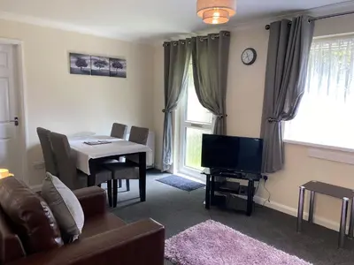 a living room with a couch and a table with a television at Lands End in Liskeard