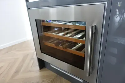 an open refrigerator door with wine bottles in it at Padstow Lodge - Padstow Holiday Village in Padstow
