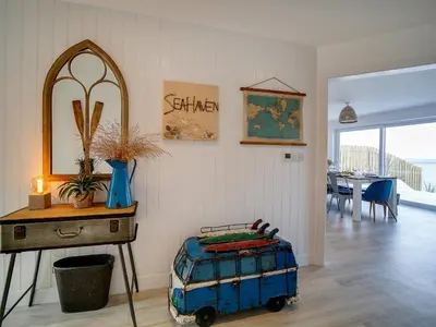 a room with a table and a suitcase on the floor at Seahaven in Port Isaac
