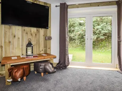 a room with a table and a tv and a window at Stall 1- The Stables in Truro