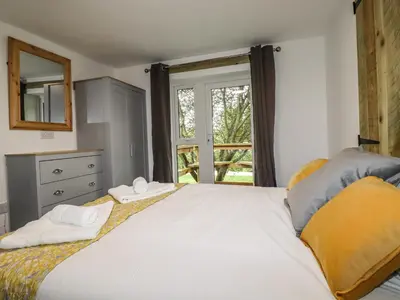 a bedroom with a large white bed with a window at Stall 1- The Stables in Truro