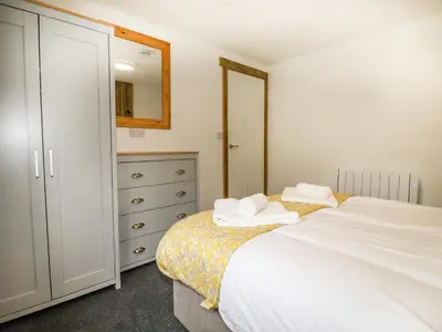 a bedroom with a bed and a dresser and a mirror at Stall 1- The Stables in Truro