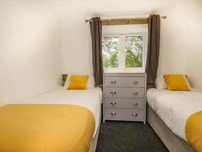 two twin beds in a room with a window at Stall 1- The Stables in Truro