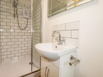a white bathroom with a sink and a shower at Stall 1- The Stables in Truro