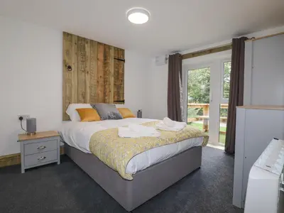a bedroom with a large bed and a window at Stall 2 - The Stables in Truro
