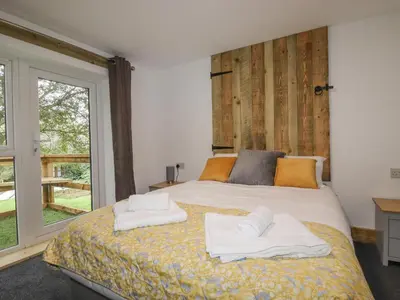 a bedroom with a large bed with towels on it at Stall 2 - The Stables in Truro