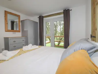 a bedroom with a large white bed and a window at Stall 2 - The Stables in Truro