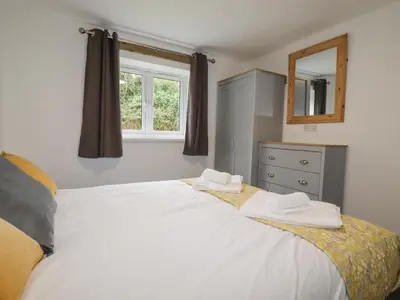 a bedroom with a large white bed and a window at Stall 2 - The Stables in Truro