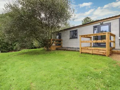 a house with a grass yard in front of it at Stall 2 - The Stables in Truro