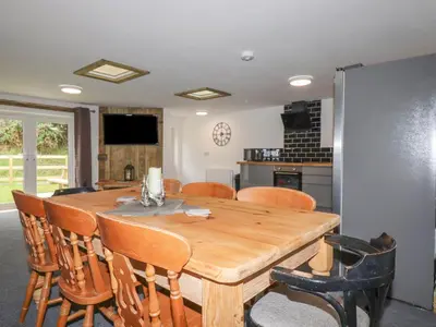 a kitchen and dining room with a wooden table and chairs at Stall 2 - The Stables in Truro