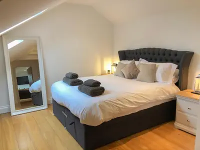 a bedroom with a large bed with towels on it at The Hideaway in St Ives