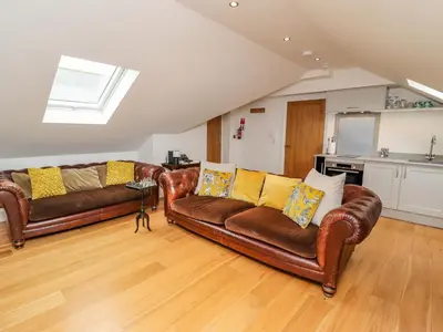 a living room with two leather couches and a kitchen at The Hideaway in St Ives
