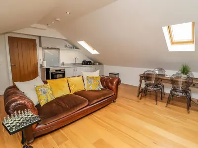a living room with a brown couch and a table at The Hideaway in St Ives