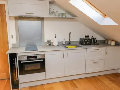 a kitchen with white cabinets and a stove at The Hideaway in St Ives