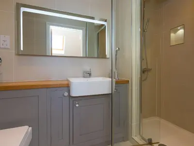 a bathroom with a sink and a shower and a mirror at 7 Four Seasons in St Ives