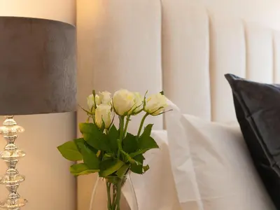 a vase with white flowers on a table next to a lamp at 7 Four Seasons in St Ives