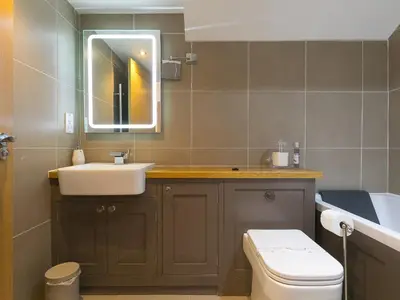 a bathroom with a sink and a toilet and a mirror at 7 Four Seasons in St Ives