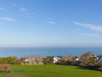 a view of a field with the ocean in the background at 7 Four Seasons in St Ives