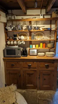 a kitchen with a counter with a microwave and plates at The Hideaway in Falmouth