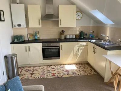 a small kitchen with white cabinets and a sink at Ocean Breeze No 5, Seaview & Parking in Falmouth