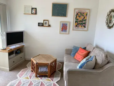 a living room with a couch and a tv at Ocean Breeze No 5, Seaview & Parking in Falmouth