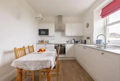 a kitchen with a table with a bowl of fruit on it at Seaside Holiday Cottage Near Beach in Charlestown