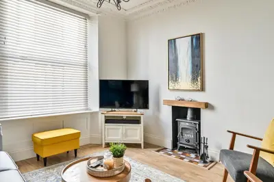 a living room with a television and a fireplace at Luxury Georgian Townhouse Moments from the Harbour in Looe
