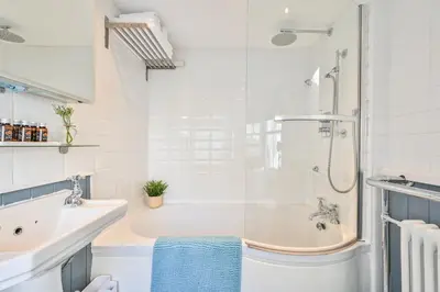 a white bathroom with a tub and a sink at Luxury Georgian Townhouse Moments from the Harbour in Looe