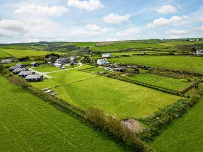 an aerial view of a farm with houses in a field at Stable Cottage in Port Isaac