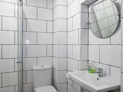 a bathroom with a toilet and a sink and a mirror at Stable Cottage in Port Isaac