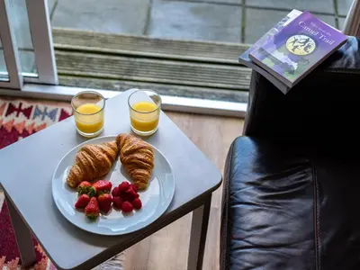 a plate of croissants and strawberries and two glasses of orange juice at Atlantic Lodge in Port Isaac
