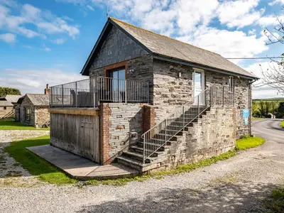a brick building with a staircase on the side of it at Swallow Cottage, Trewetha Farm in Port Isaac