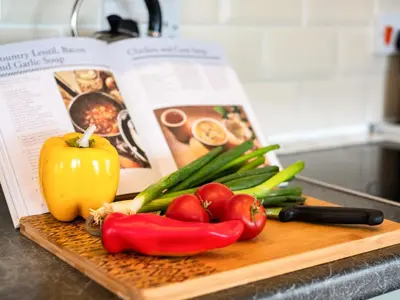 a cutting board with vegetables on top of a book at Swallow Cottage, Trewetha Farm in Port Isaac