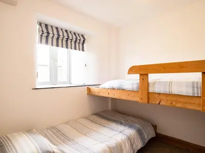 two bunk beds in a room with a window at Swallow Cottage, Trewetha Farm in Port Isaac