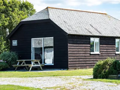 a black house with a picnic table in front of it at Gull Lodge in Port Isaac