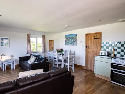 a living room with a couch and a table at Harbour Lodge in Port Isaac