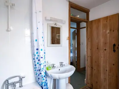 a bathroom with a sink and a shower curtain at Harbour Lodge in Port Isaac