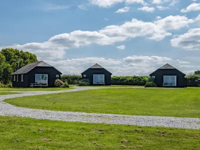 two houses on a grassy field with a gravel road at Harbour Lodge in Port Isaac