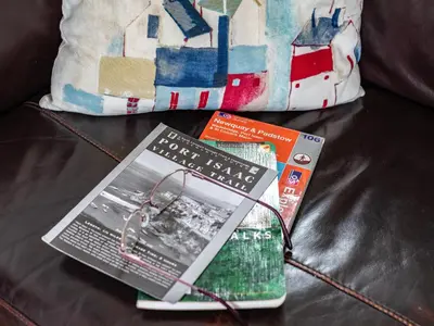 two books sitting on a couch next to a pillow at Campion Lodge in Port Isaac
