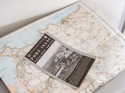 a book sitting on top of a map at Puffin Lodge in Port Isaac