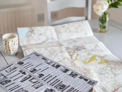 a table with two maps and a cup on it at Dolphin Lodge in Port Isaac
