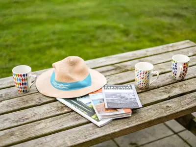 a picnic table with a hat and two coffee cups at Dolphin Lodge in Port Isaac