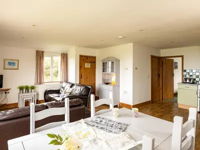a living room with a table and a couch at Dolphin Lodge in Port Isaac