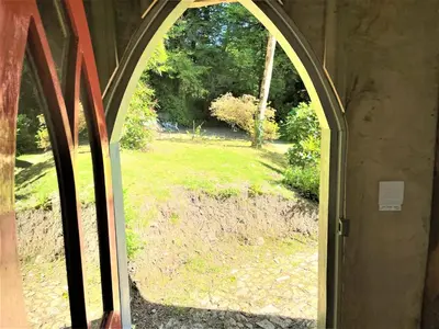 an arched window with a view of a yard at Wodehouse in Falmouth