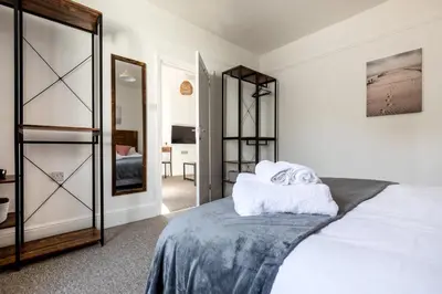 a bedroom with a bed and a mirror at Little Haven in Falmouth