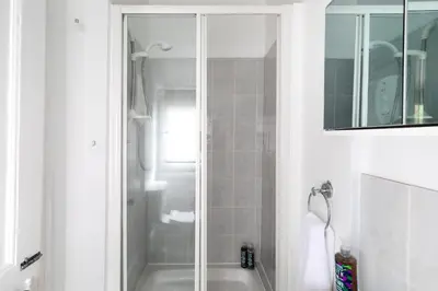 a bathroom with a shower and a bath tub at Little Haven in Falmouth