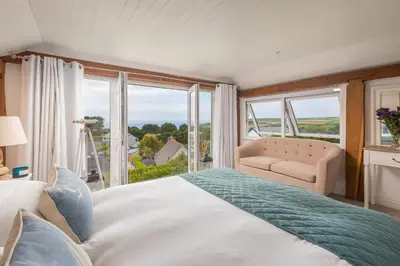 a bedroom with a large bed and a large window at Trewartha in Penzance